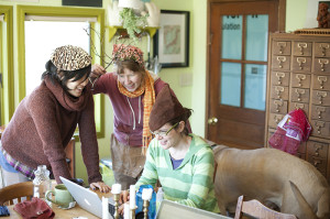 piper and molly and Dee Kim wearing funny hats aand working on computers in the old farmhouse