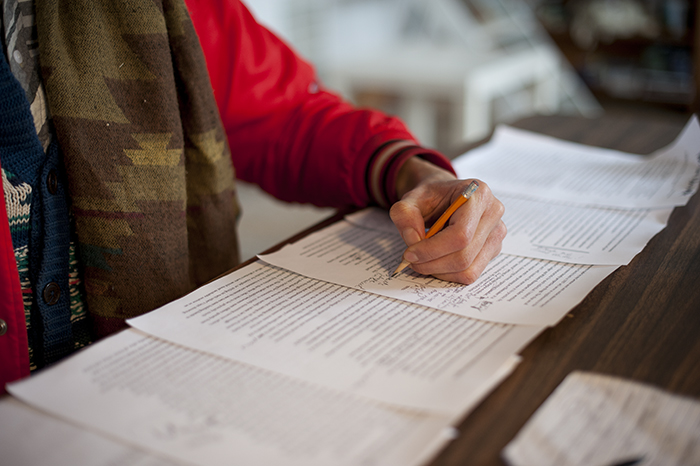 artist Magnus Elias Rosengarten writing left hand notes on pieces of paper printed with text